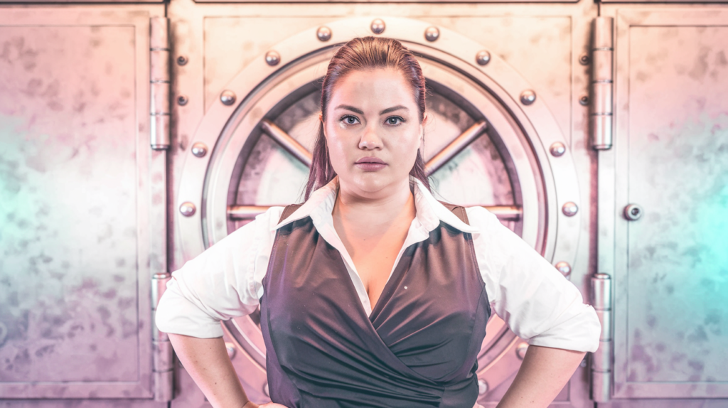 Determined woman with key labeled 'Women-Focused Grants' trying to unlock funding vault